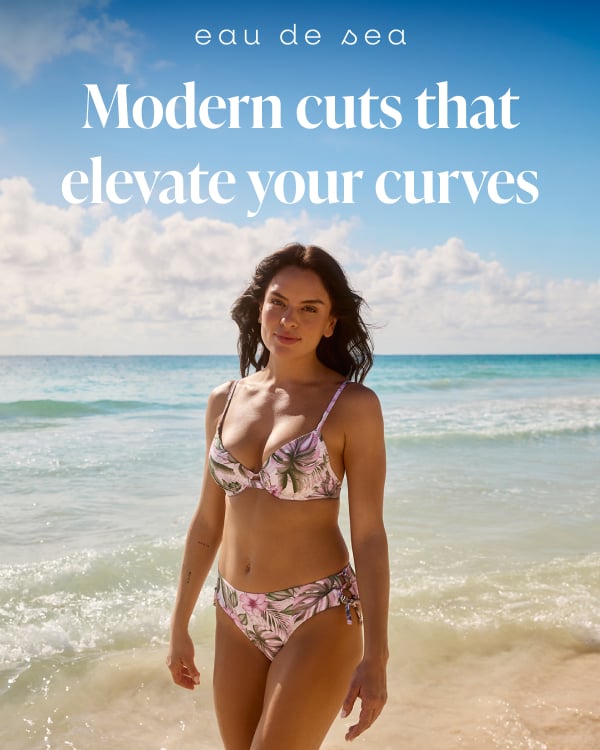 A woman on a beach wearing a tropical‑print bikini set from the brand Eau de Sea. 